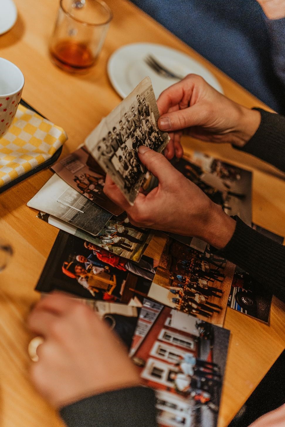 In een hand oude kaarten en foto's uit het verleden